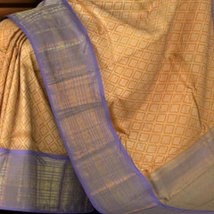 Light Orange Kanchipuram Silk Saree with large diamond motif design on the body with lavender contrast border featuring varusai pet border and annam, small diamond designs in pallu