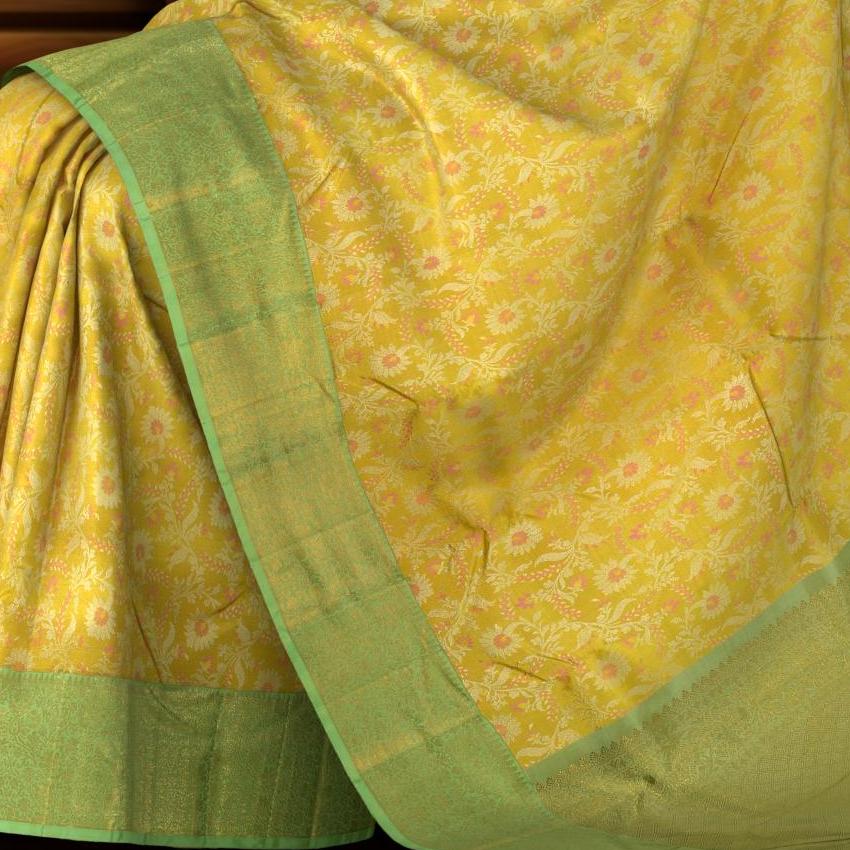 Yellow Kanchipuram Silk Saree with pink flower designs on the body with pista green contrast border and grand floral design with diamond motif in pallu